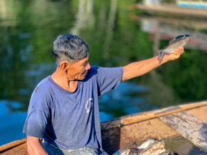 Man in canoe holding fish