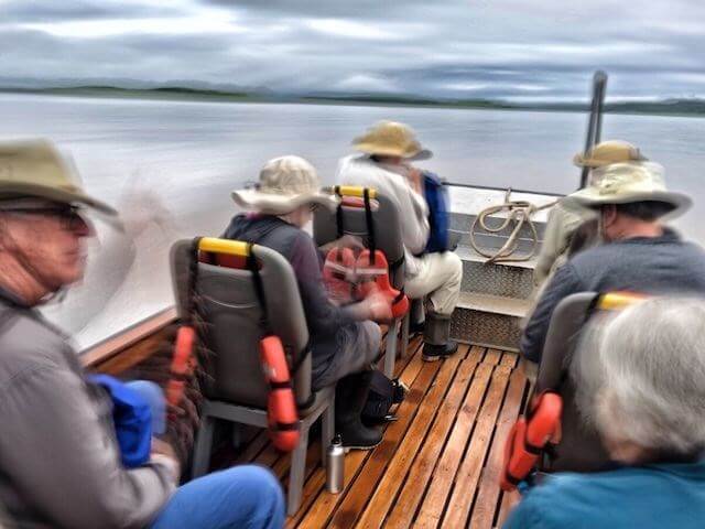 Passengers on a skiff speeding through the waters of the Amazon